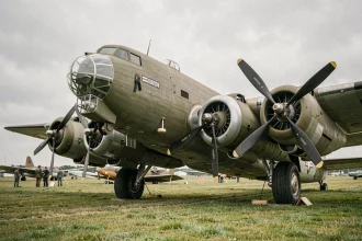 Boeing B-17F Flying Fortress restauré sur une piste en herbe, moteurs radiaux Wright Cyclone visibles en gros plan, perspective 3/4 avant